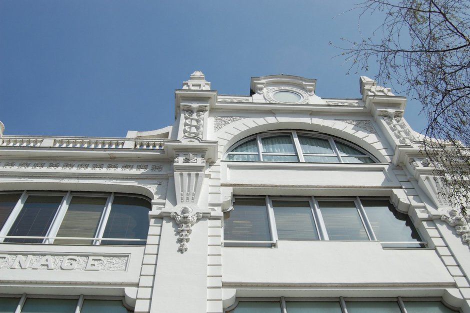 Une partie de la façade, blanche, avec ses grandes baies vitrée dont celles du dôme, ses chapiteaux et linteaux sculptés.